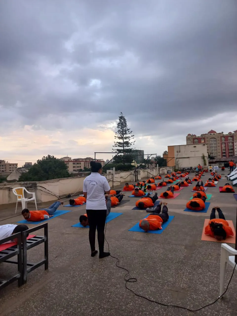 Large rooftop group yoga class guided by a Pathak's Vitality instructor